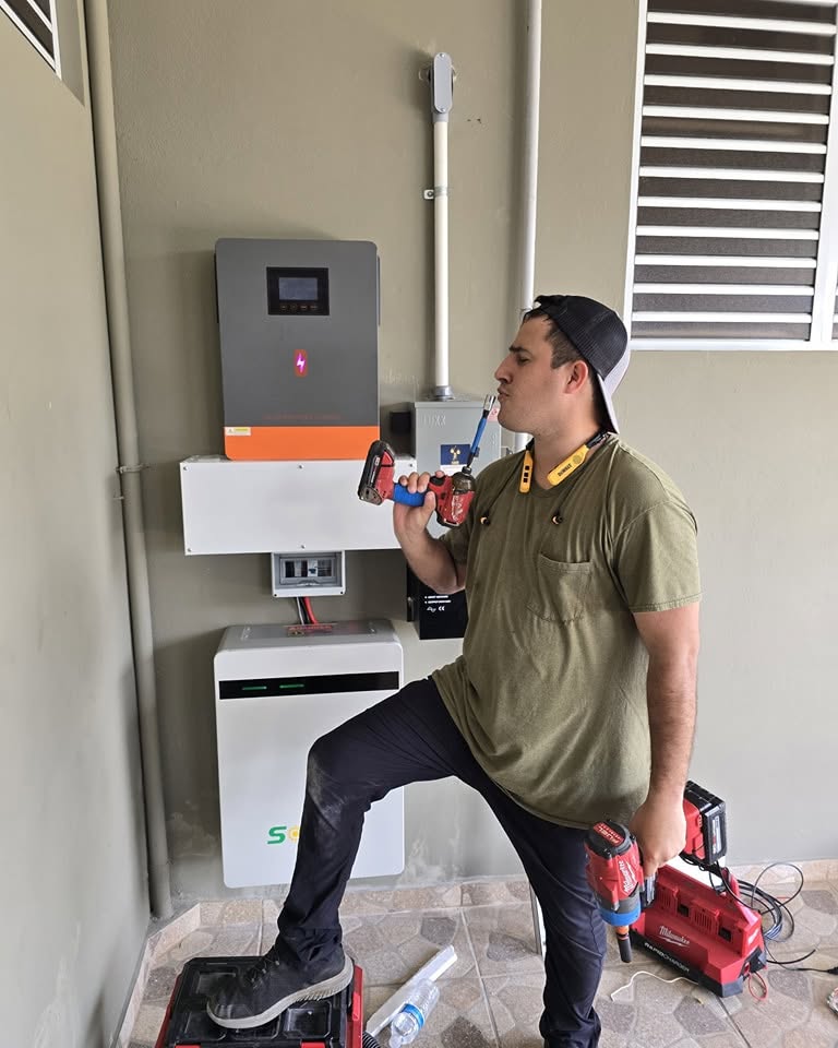 Técnico de Tec787 junto a un inversor y batería recién instalados